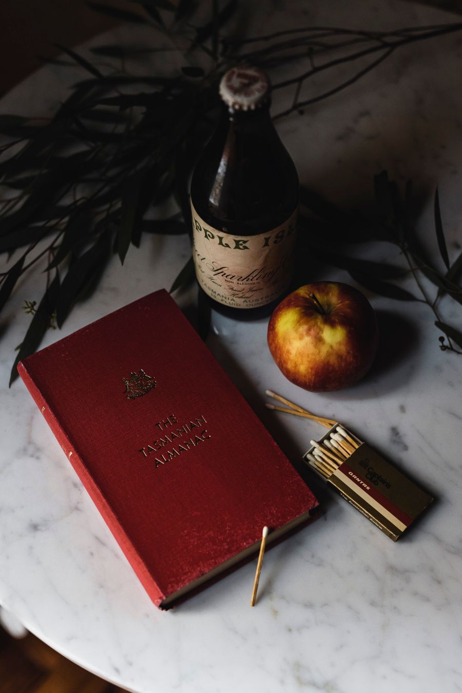 Tasmanian Almanac book on table with apple and apple wine bottle