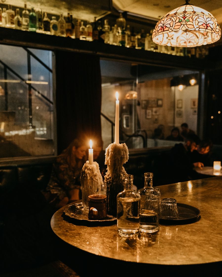 image of candles on table with drinks in a bar