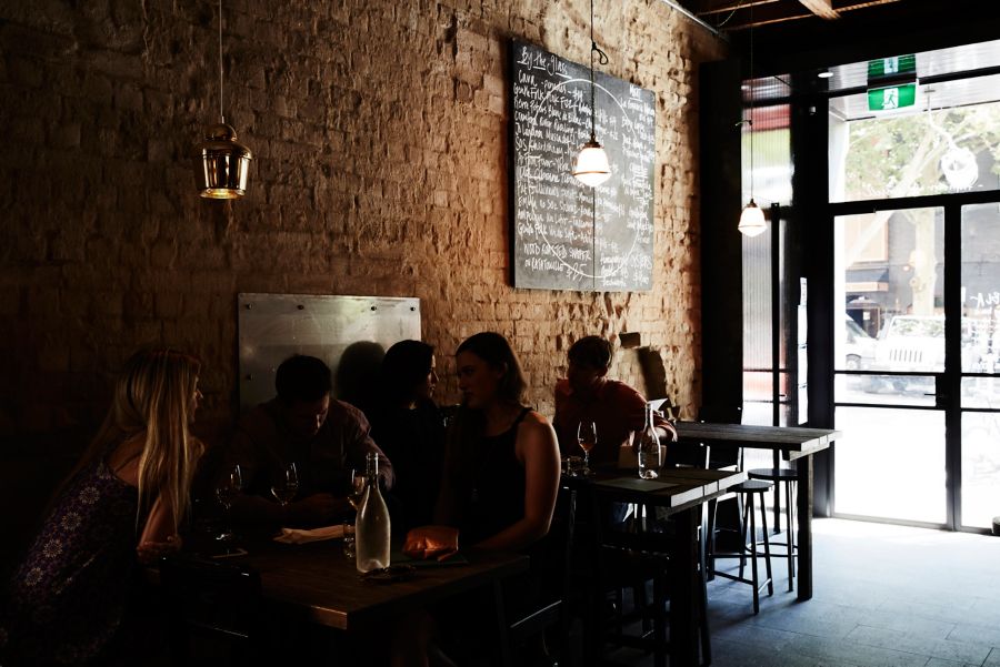 people sitting in a restaurant with liquor bottles on their table