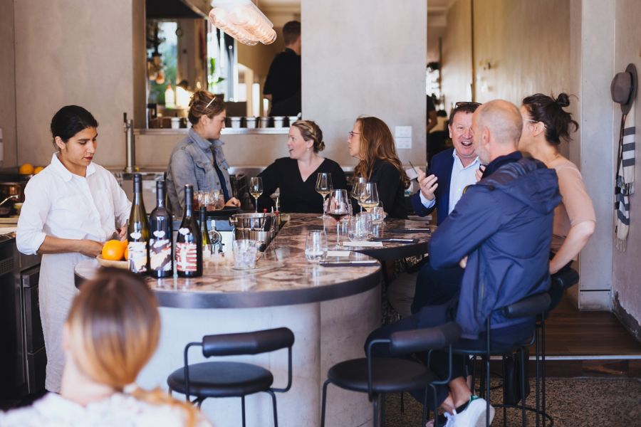 people enjoying drinks and food at etta bar
