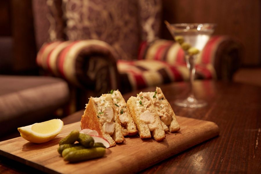 Image of snacks served on wooden plate in gin palace bar