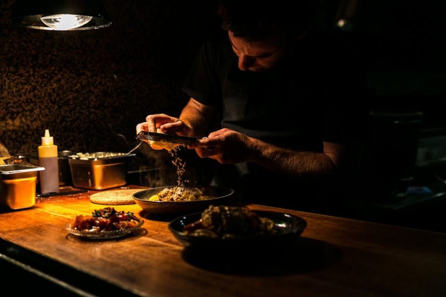 A chef finishing a dish in the kitchen