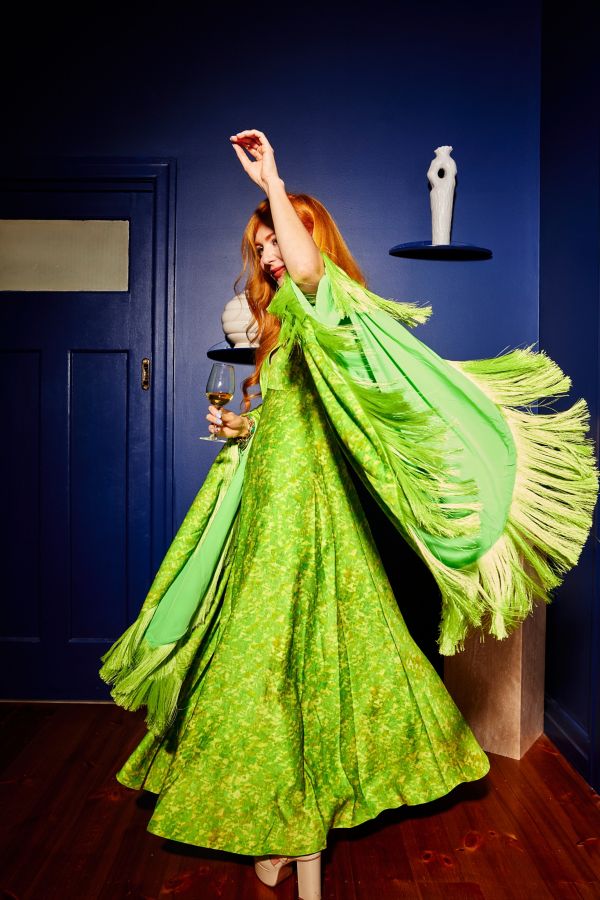 Kelly Thompson dancing in a retro green dress with tassels