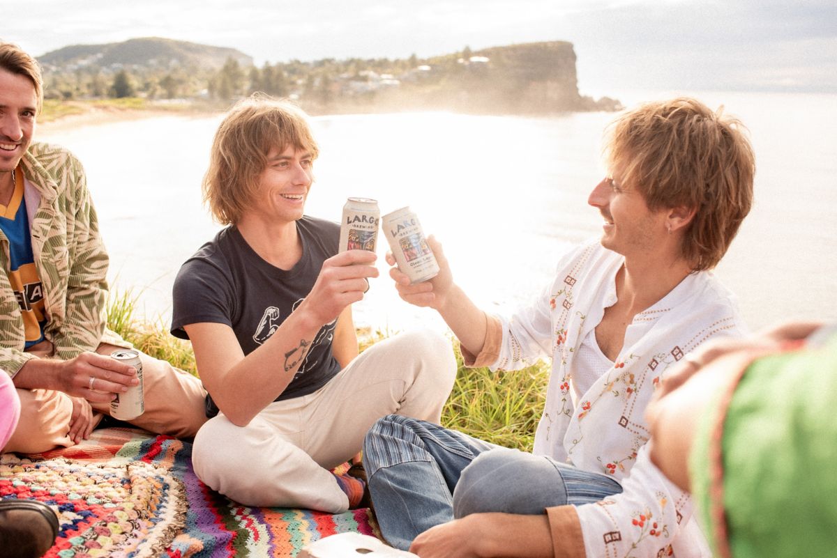 Louis and Oli toasting with cans of LARGO Beer at picnic