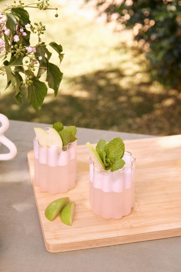 Two Shameless Sour cocktails, garnished with mint and apple