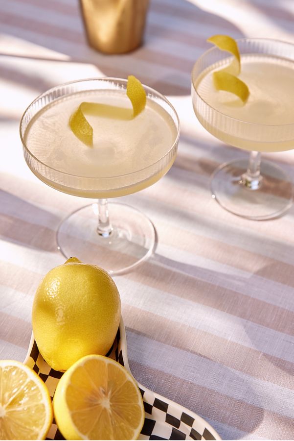 Two Bee's Knees cocktails, garnished with lemon twists