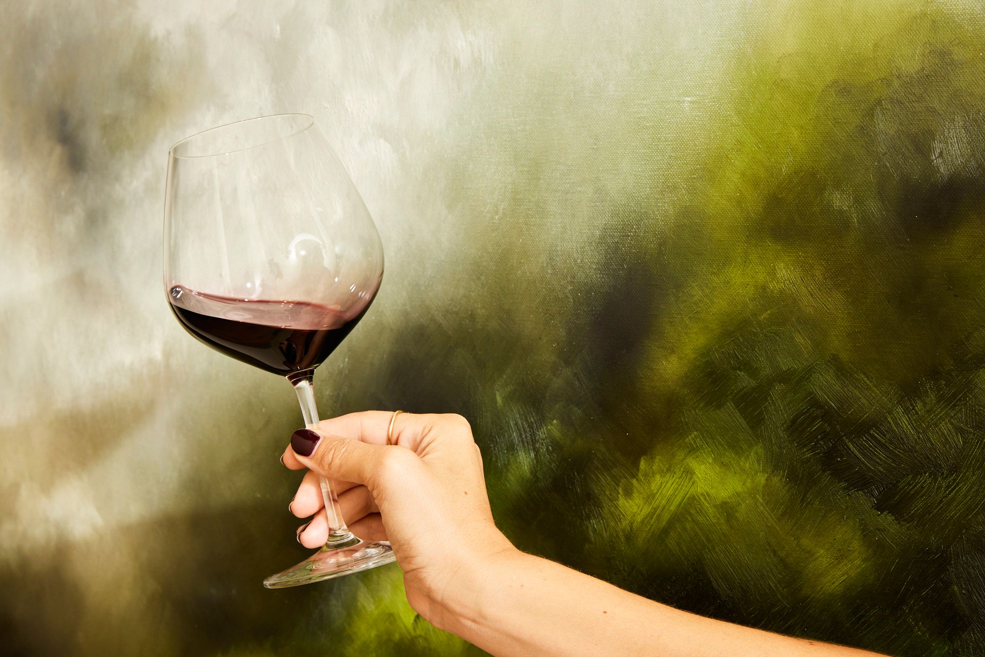 Holding a glass of red wine