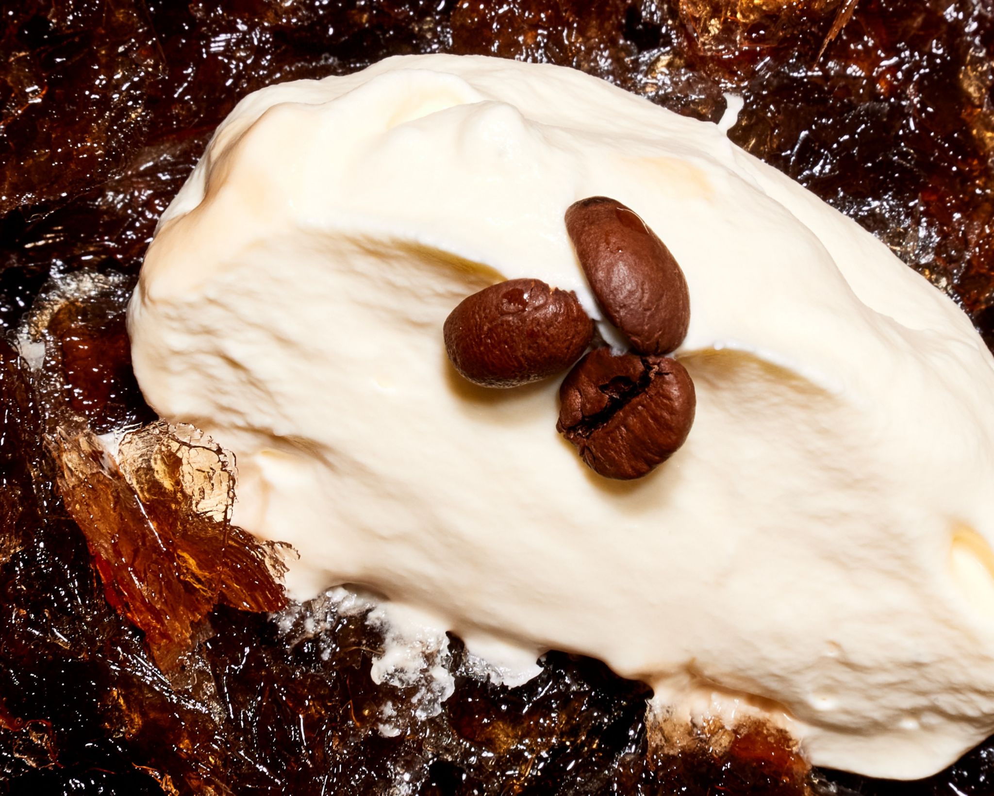 A close-up of the Espresso Martini Granita, which is finished with a dollop of cream 