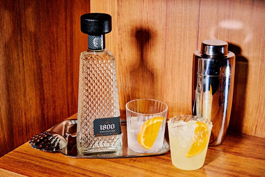 A bottle of 1800 Cristalino Tequila with two cocktails