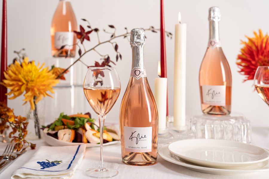 Kylie MInogue 0% Sparkling Rosé on a table set with candles and  flowers