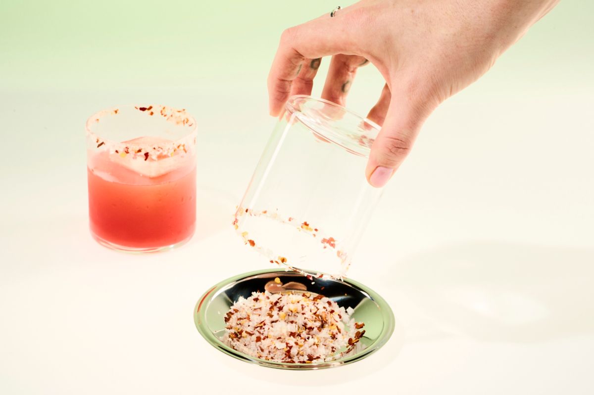 Adding a chilli salt rim to a glass for the Hot Pink Punch