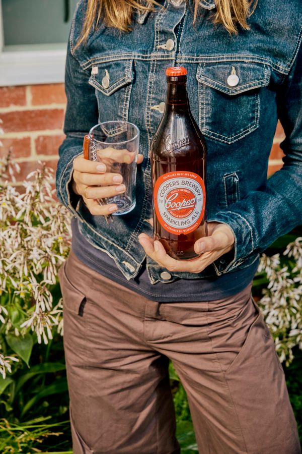 Holding a longneck of Coopers Sparkling Ale in a backyard&nbsp;