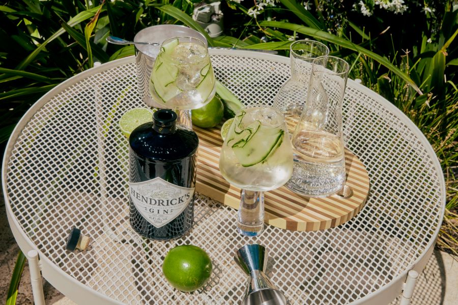A bottle of Hendrick's Gin with G&Ts on an outdoor table