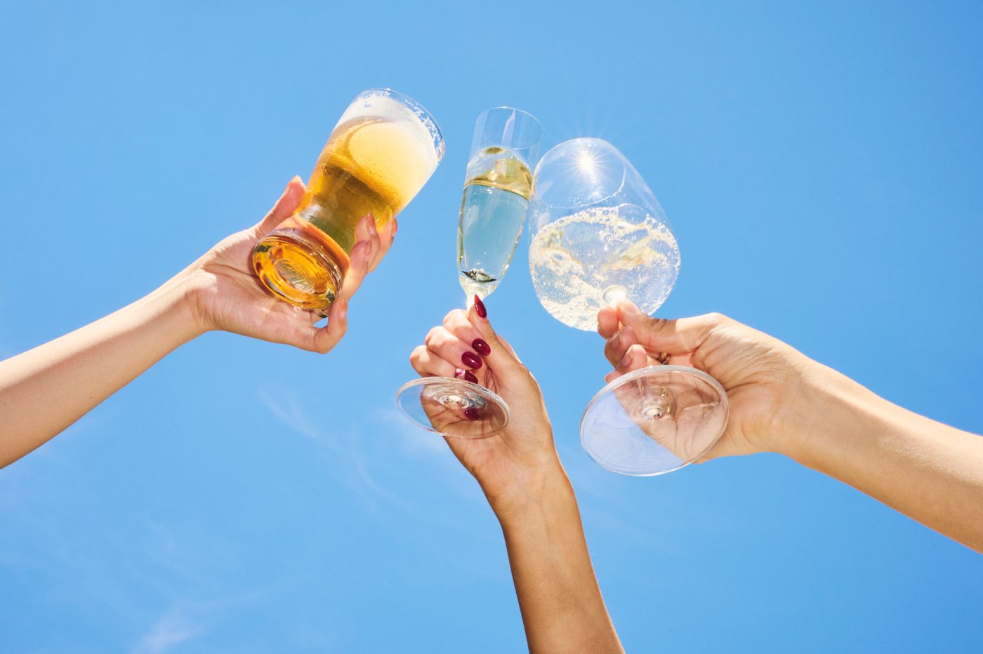 Looking up at glasses in the air as friends clink glasses and cheers 