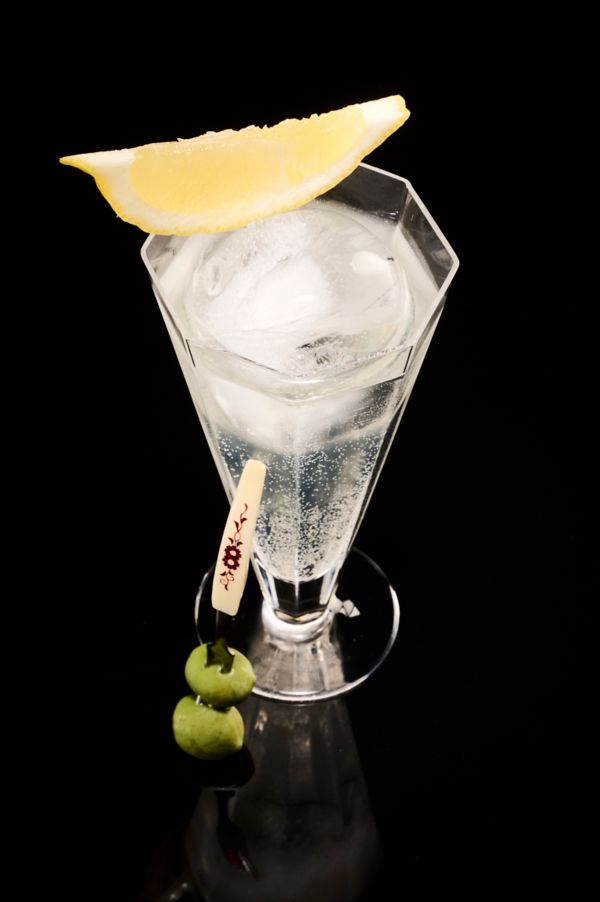 The Martini Highball, garnished with a lemon wedge and olives
