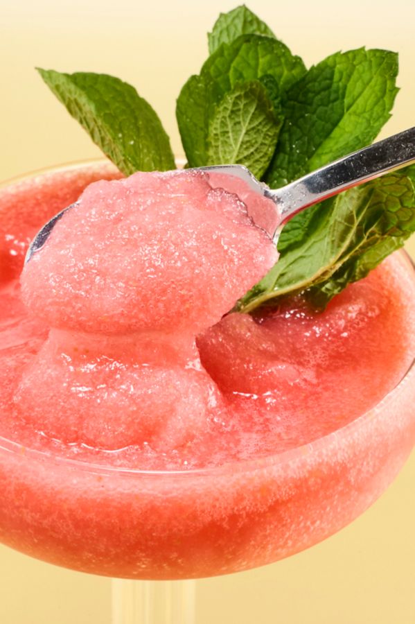 Dipping a spoon into a glass of the Frozen Raspberry Cosmo