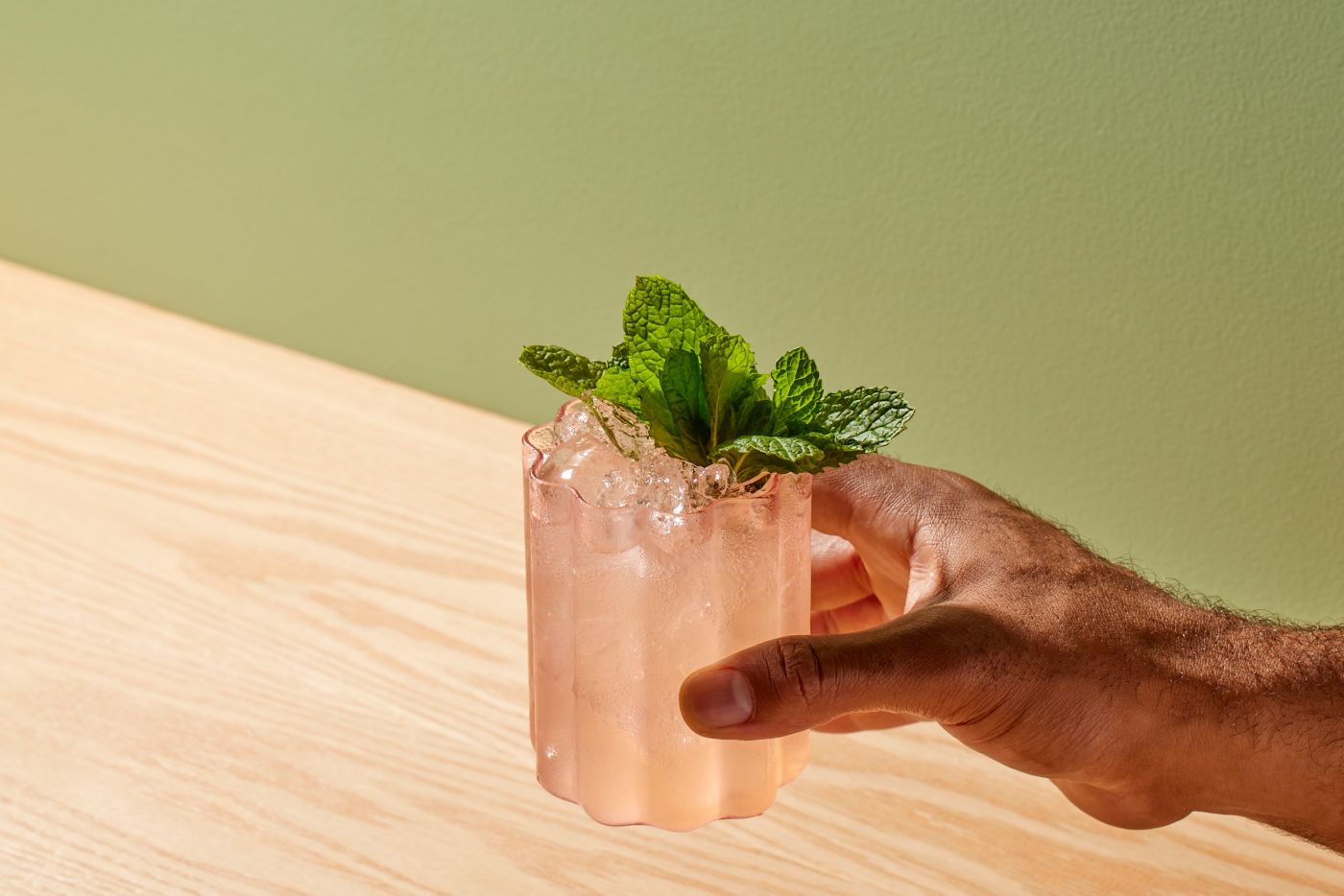 Holding a glass of the delicate Soju Garden cocktail