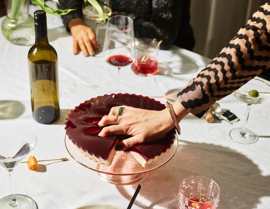 A hand in a cake at a dinner party