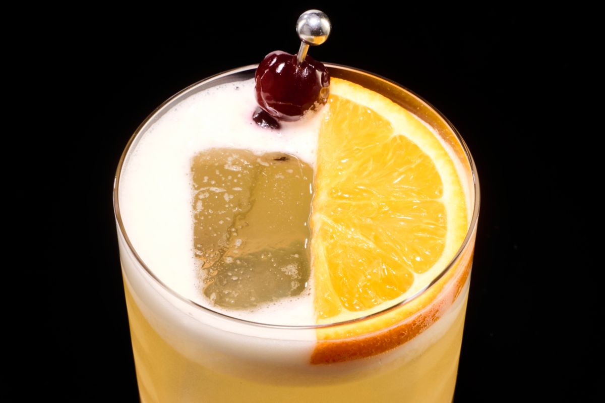 The Whiskey Sour, garnished with an orange slice and cherry 