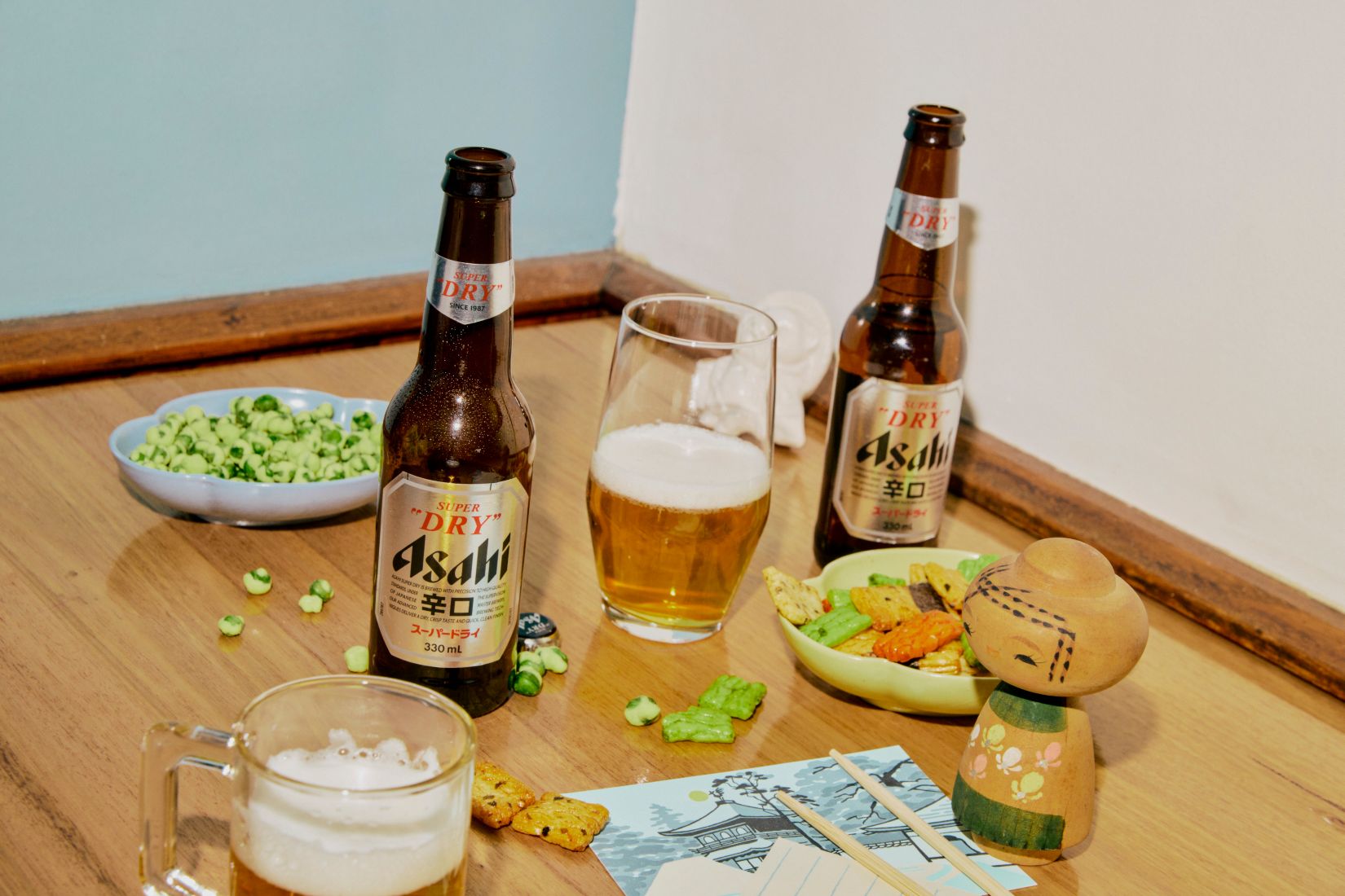 Bottles of Asahi with Japanese snacks on a table