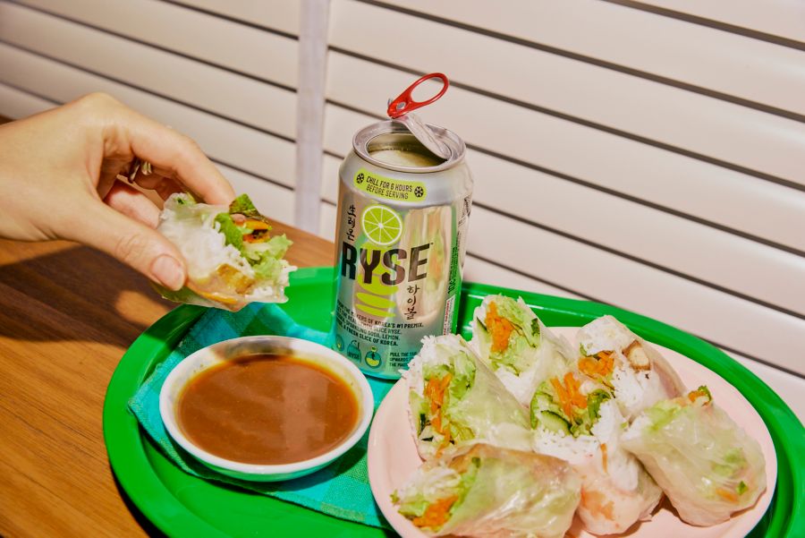 Dipping a rice paper roll into sauce, served with RYSE Vodka Lemon Soda 