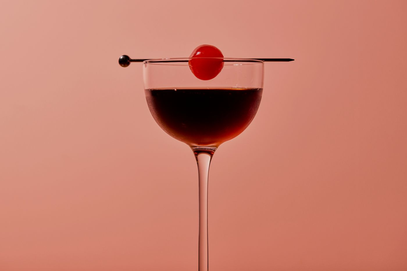 The Black Manhattan cocktail is garnished with a cherry