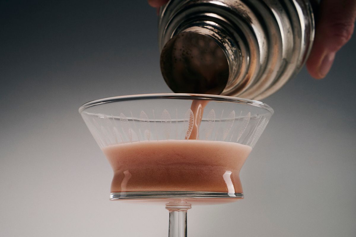Pouring the Blood Orange Amaretto Sour into the glass
