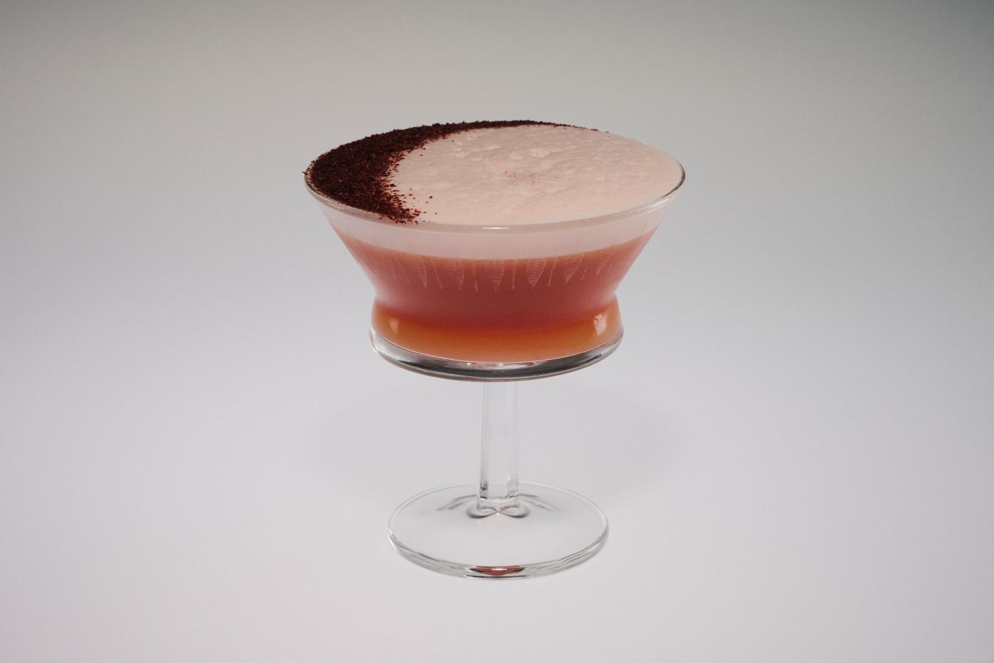 The Blood Orange Amaretto Sour in a coupe glass, garnished with sumac