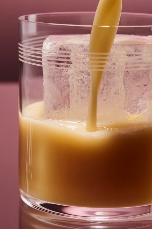 Pouring the Miso Maple Whiskey Sour into a glass over ice