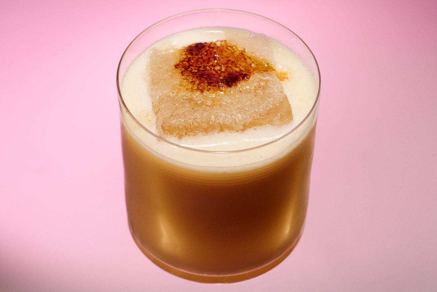 The Miso Maple Whiskey Sour cocktail on a pink background