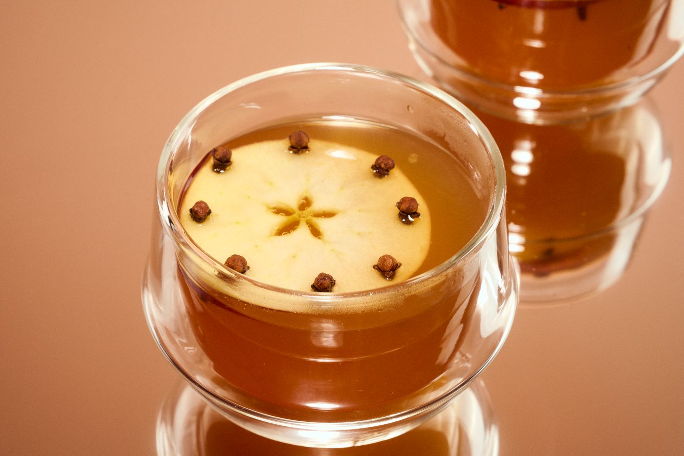 Warm Mulled Cider with clove-spiked apple as a garnish