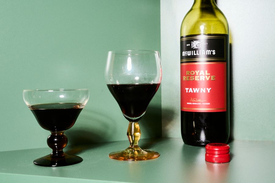 A bottle of McWilliam's Tawny with glasses in a green setting