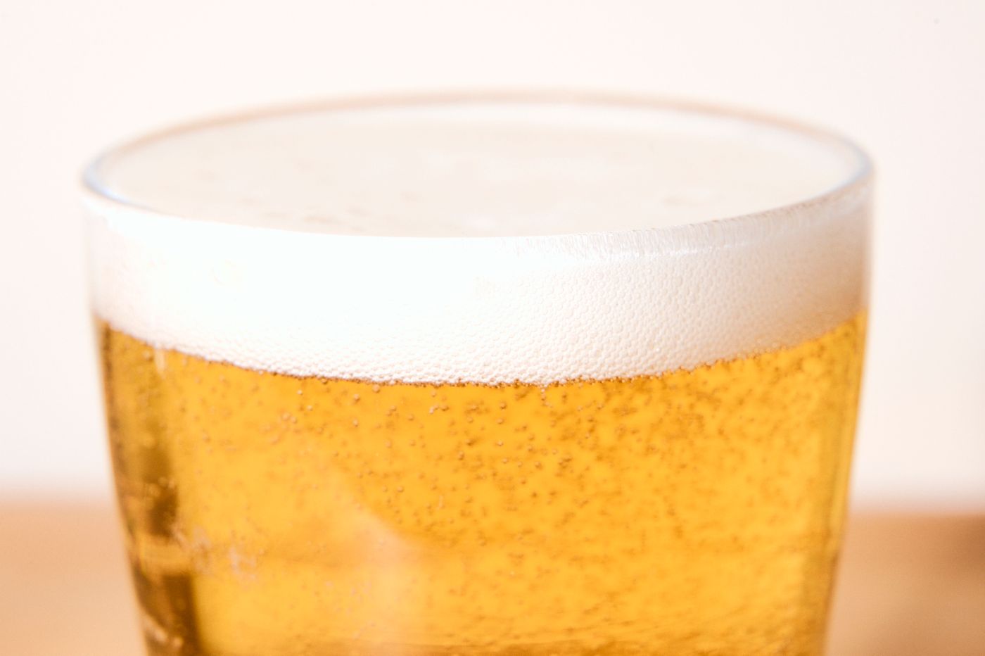 A close-up shot of a glass of beer with a frothy head