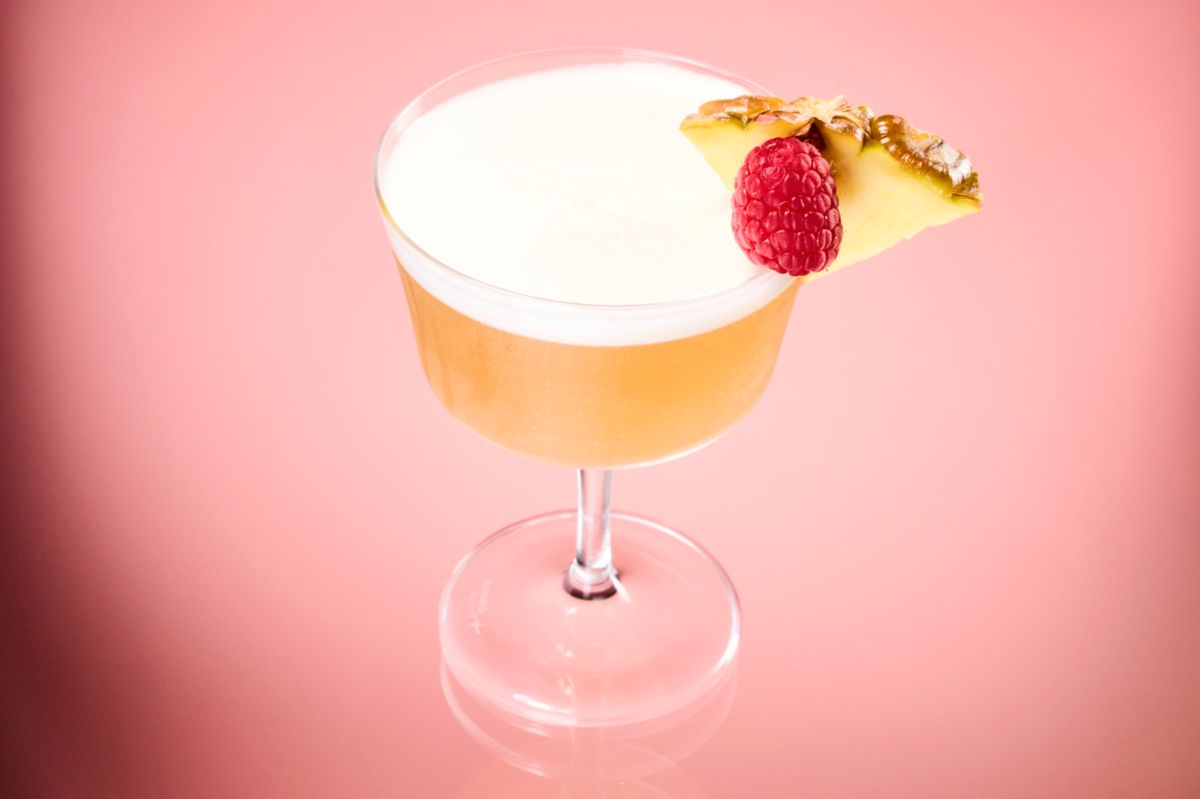 The French Martini is garnished with a pineapple wedge and raspberry