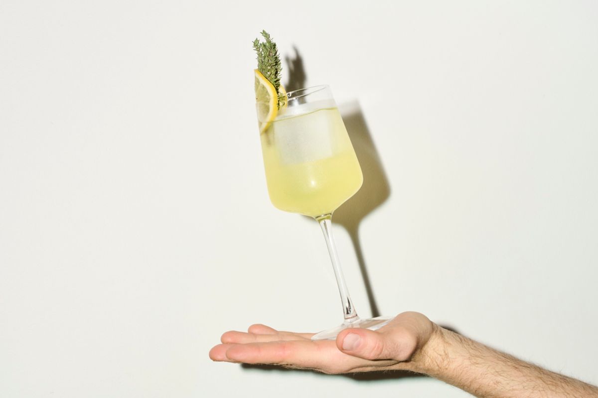 Holding a wine glass of the Limoncello Spritz