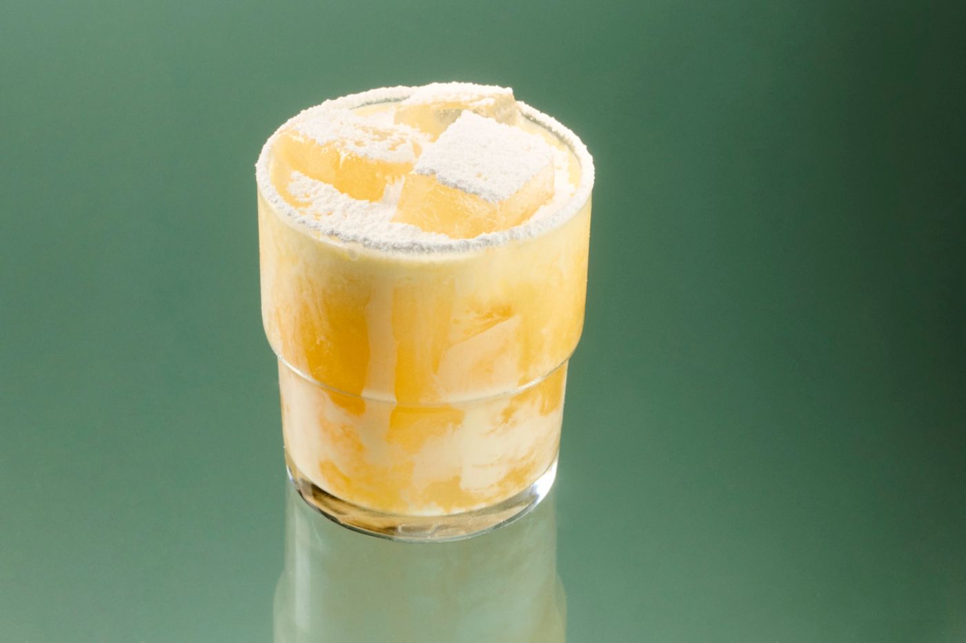 The Peach Whiskey Sour cocktail on a green background