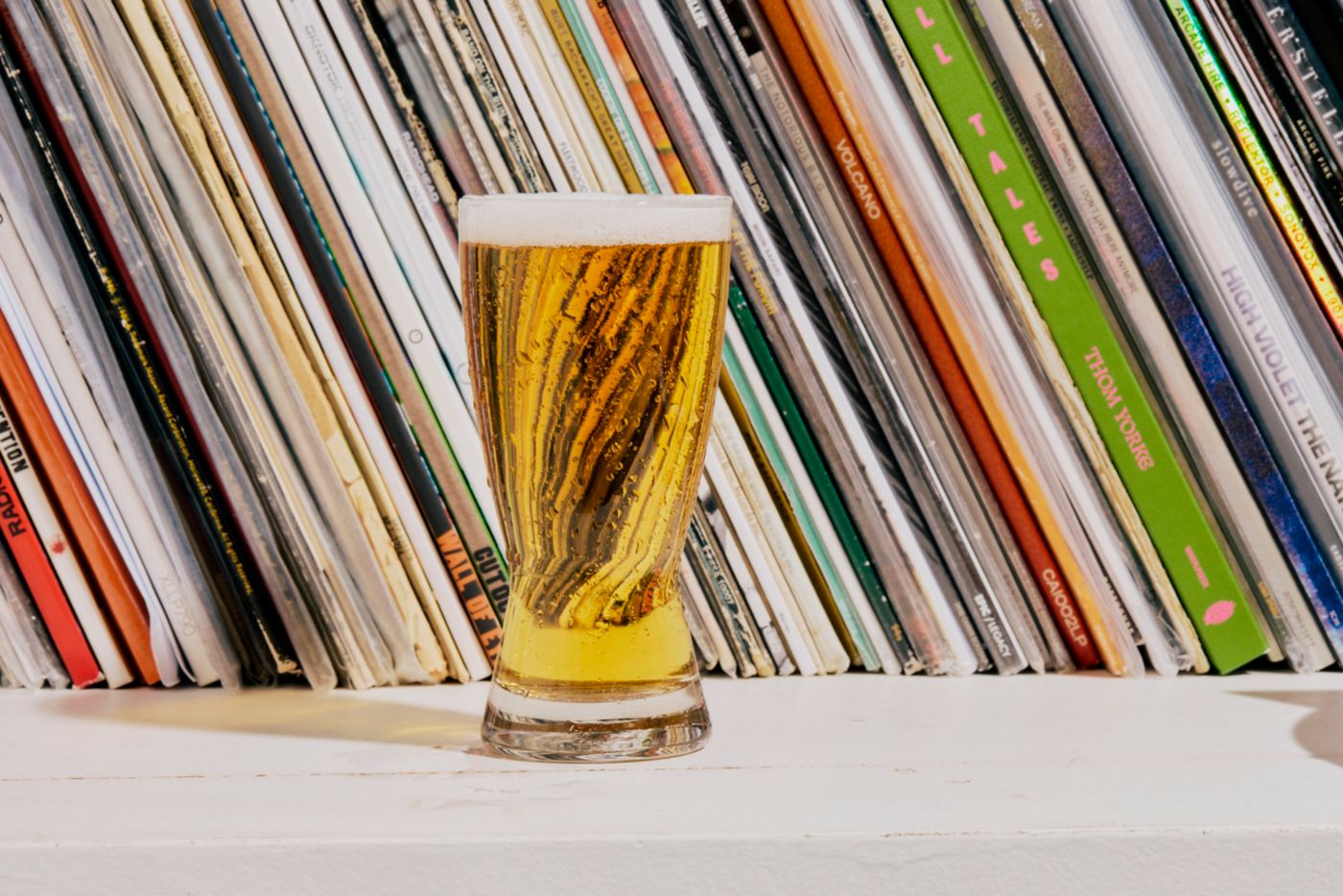 A glass of beer on a bookshelf 