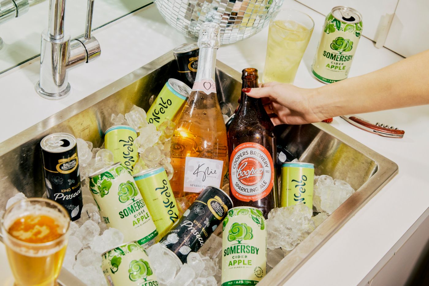 A sink full of drinks in ice ready for a party 