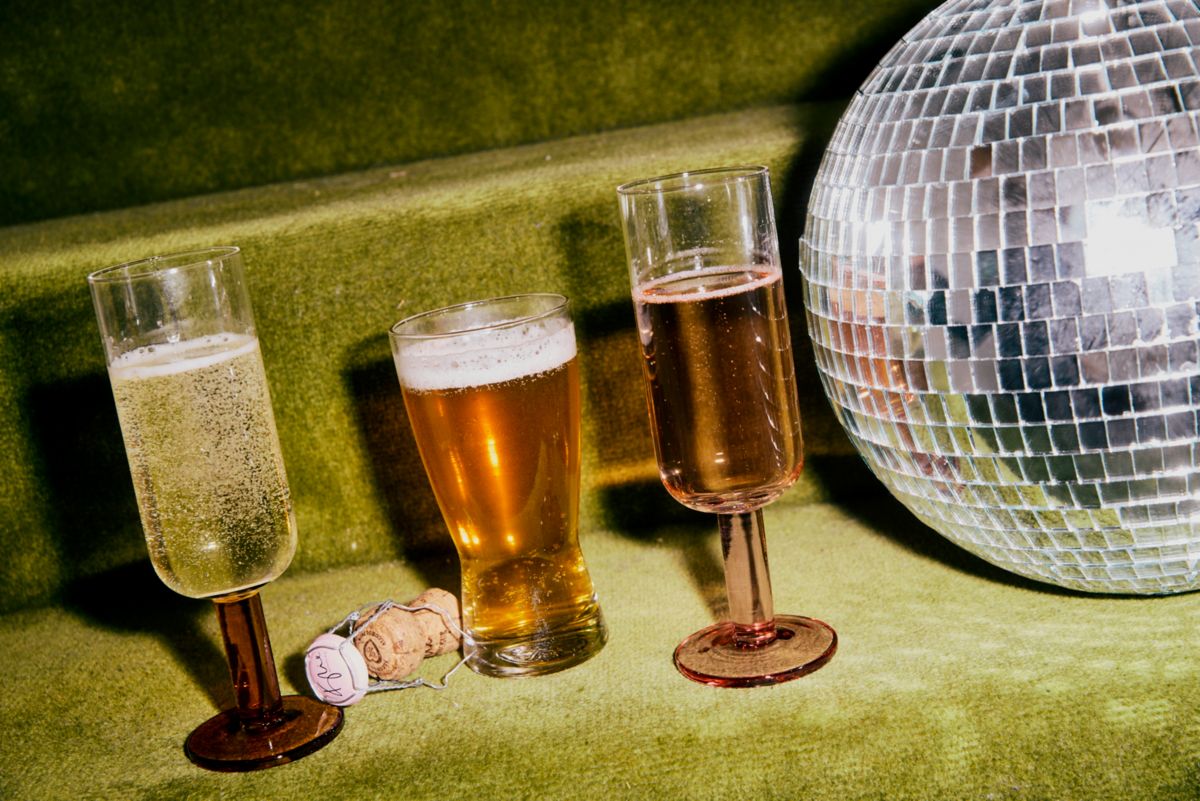 Three drinks next to a disco ball on green carpet